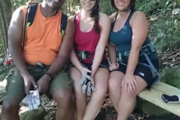 a group of people sitting on a bench posing for the camera