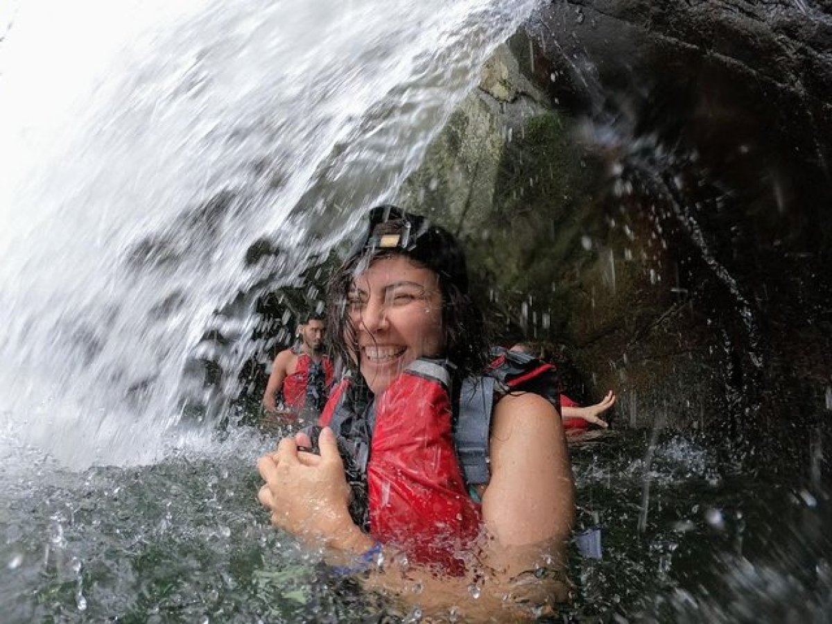 a young girl riding a wave on top of a waterfall