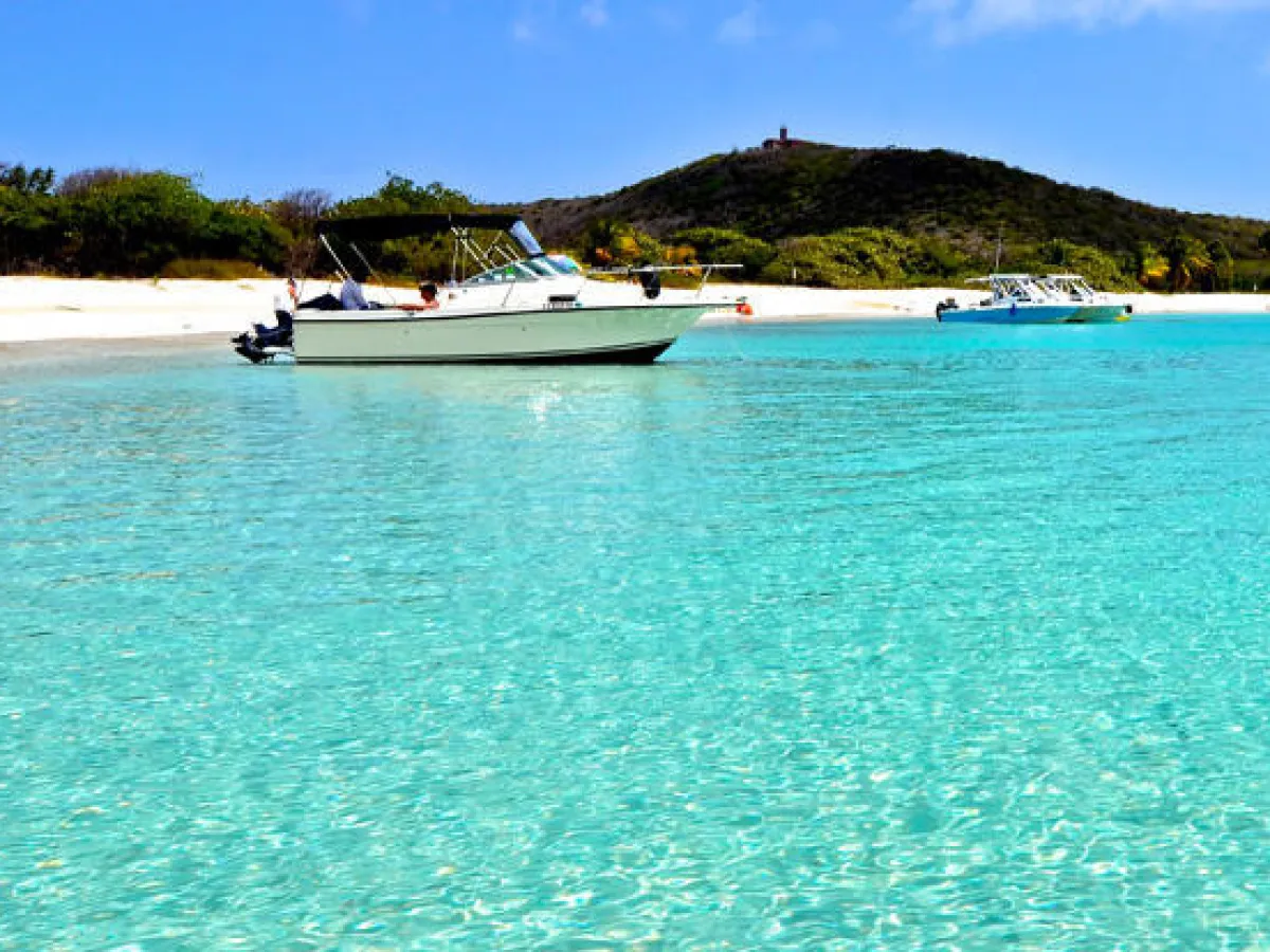 a blue and white boat sitting next to a body of water