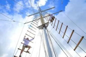 person climbing the rigging of a ship