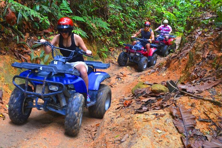 a man riding a motorcycle down a dirt road