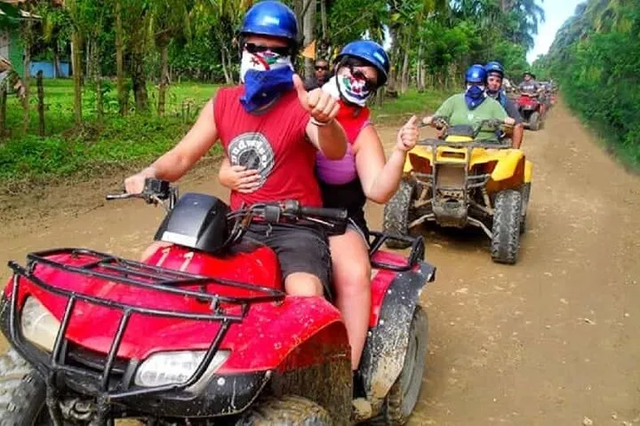 a man wearing a helmet riding a motorcycle down a dirt road