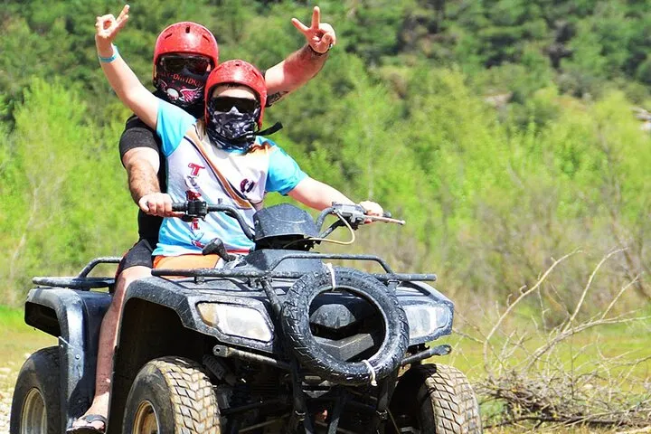 a man riding a motorcycle down a dirt road