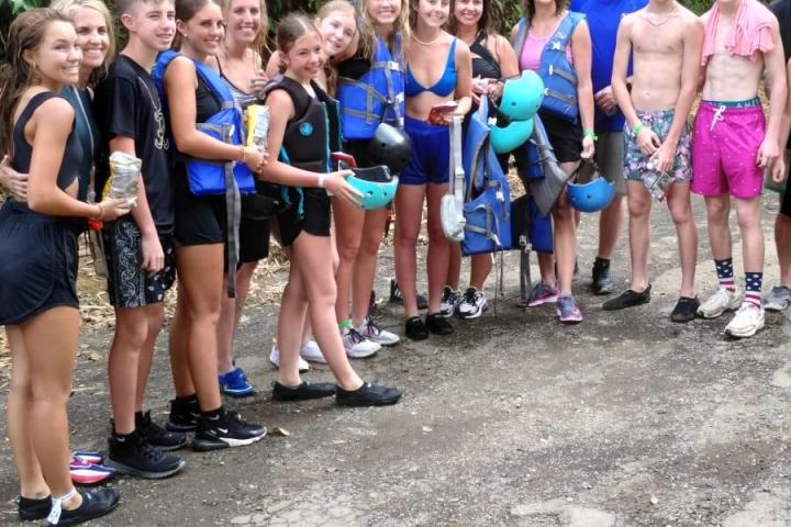 a group of people standing next to a tree