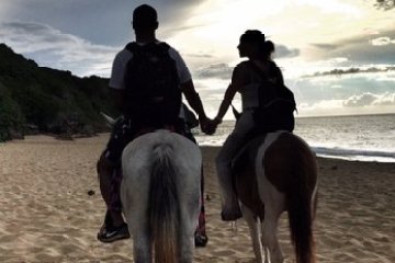 a group of people standing on top of a sandy beach