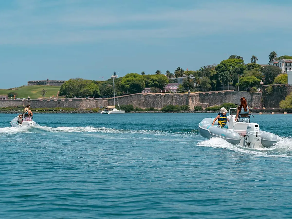 a group of people riding on the back of a boat in the water