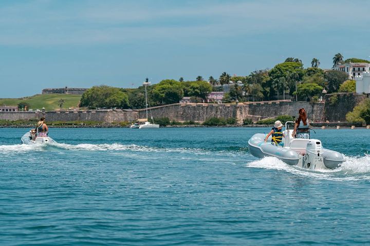 a group of people riding on the back of a boat in the water