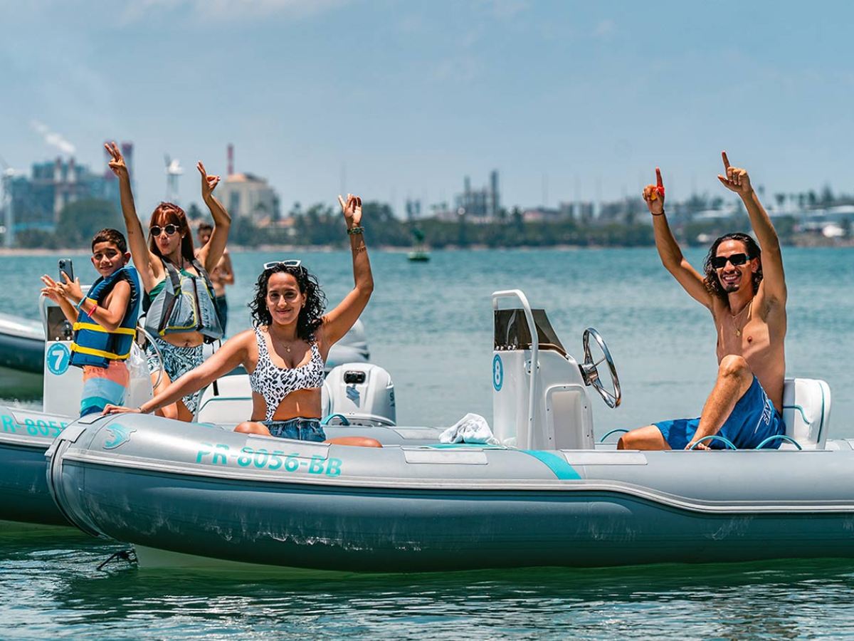 a group of people riding on the back of a boat in the water