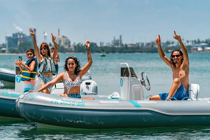 a group of people riding on the back of a boat in the water