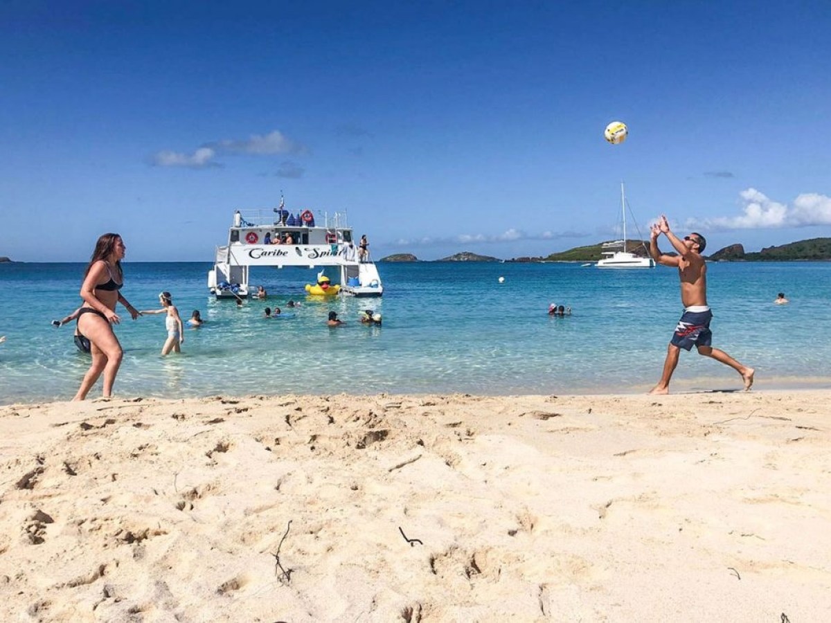a couple of people that are standing in the sand on a beach