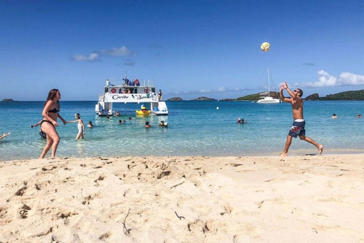 a couple of people that are standing in the sand on a beach