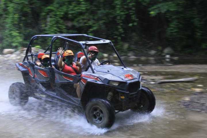 a man riding on the back of a car going down the river