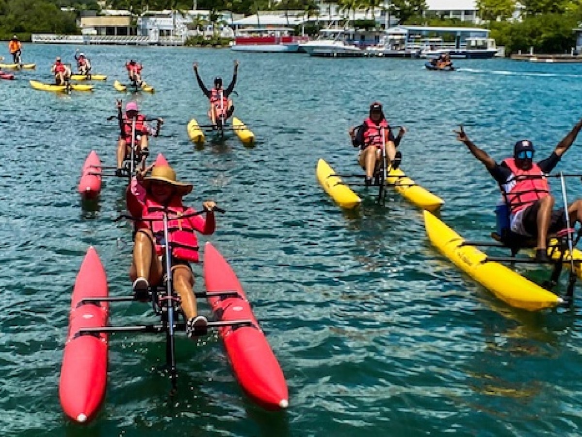 a group of people riding on the back of a boat in the water