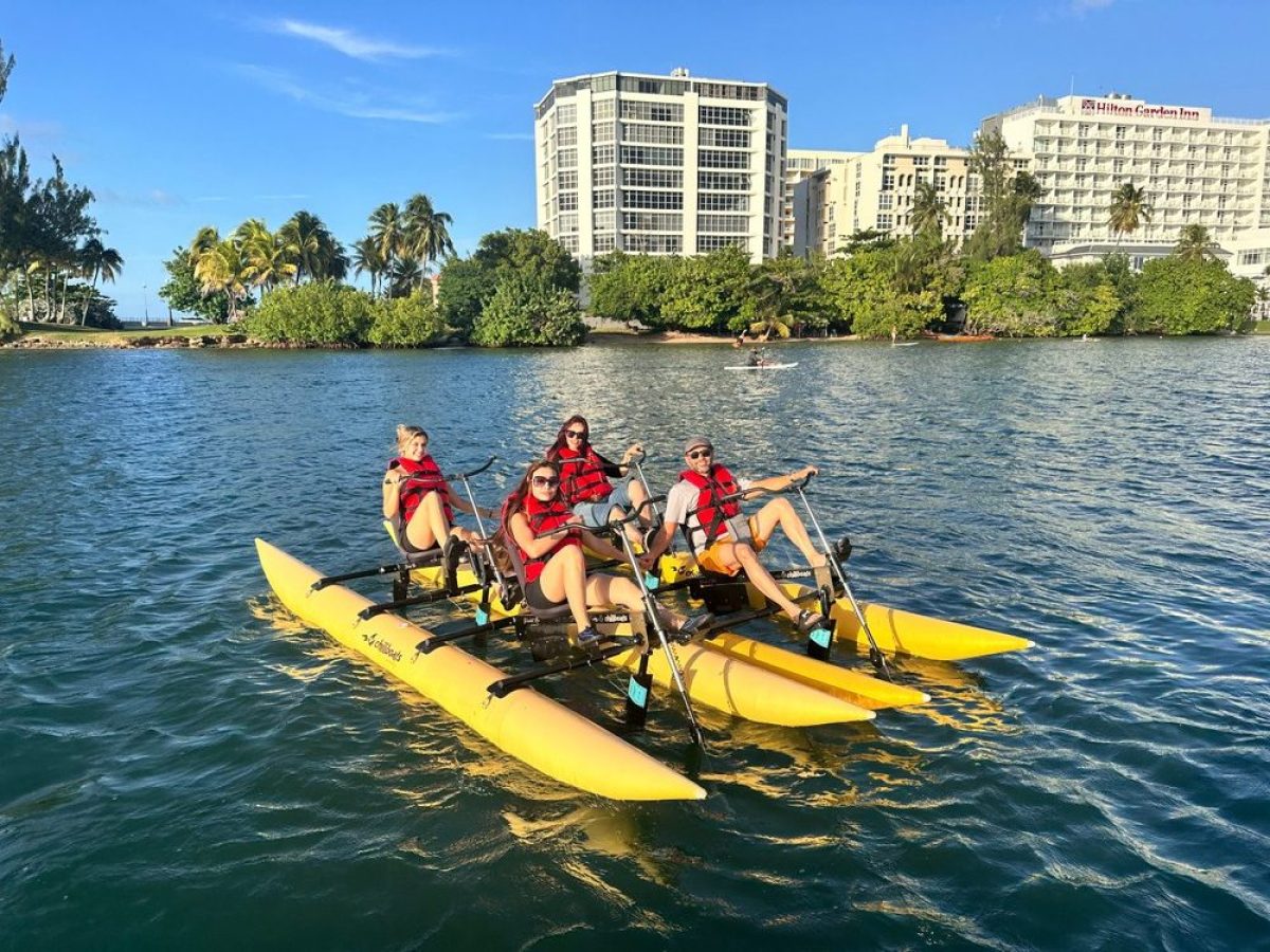a group of people riding on the back of a boat in the water