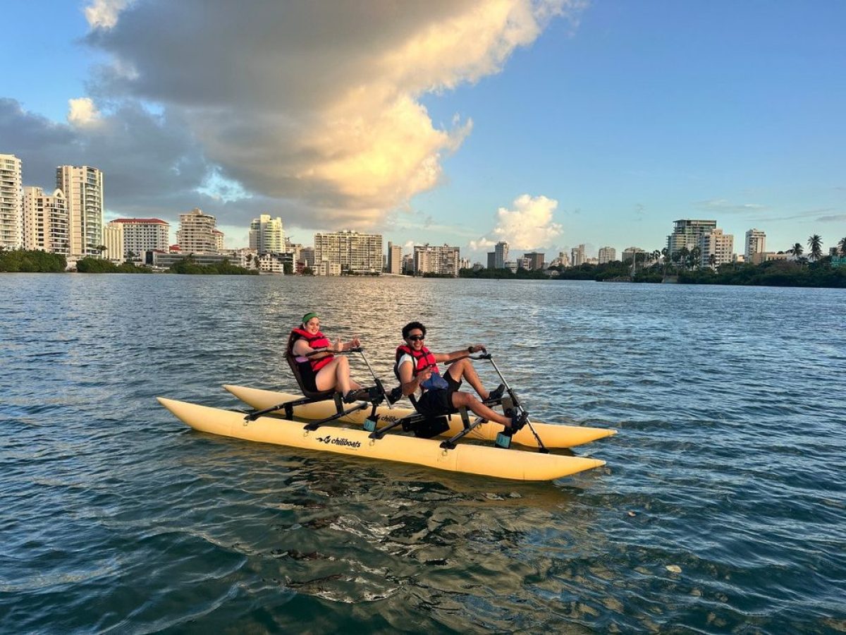 a group of people riding on the back of a boat in the water