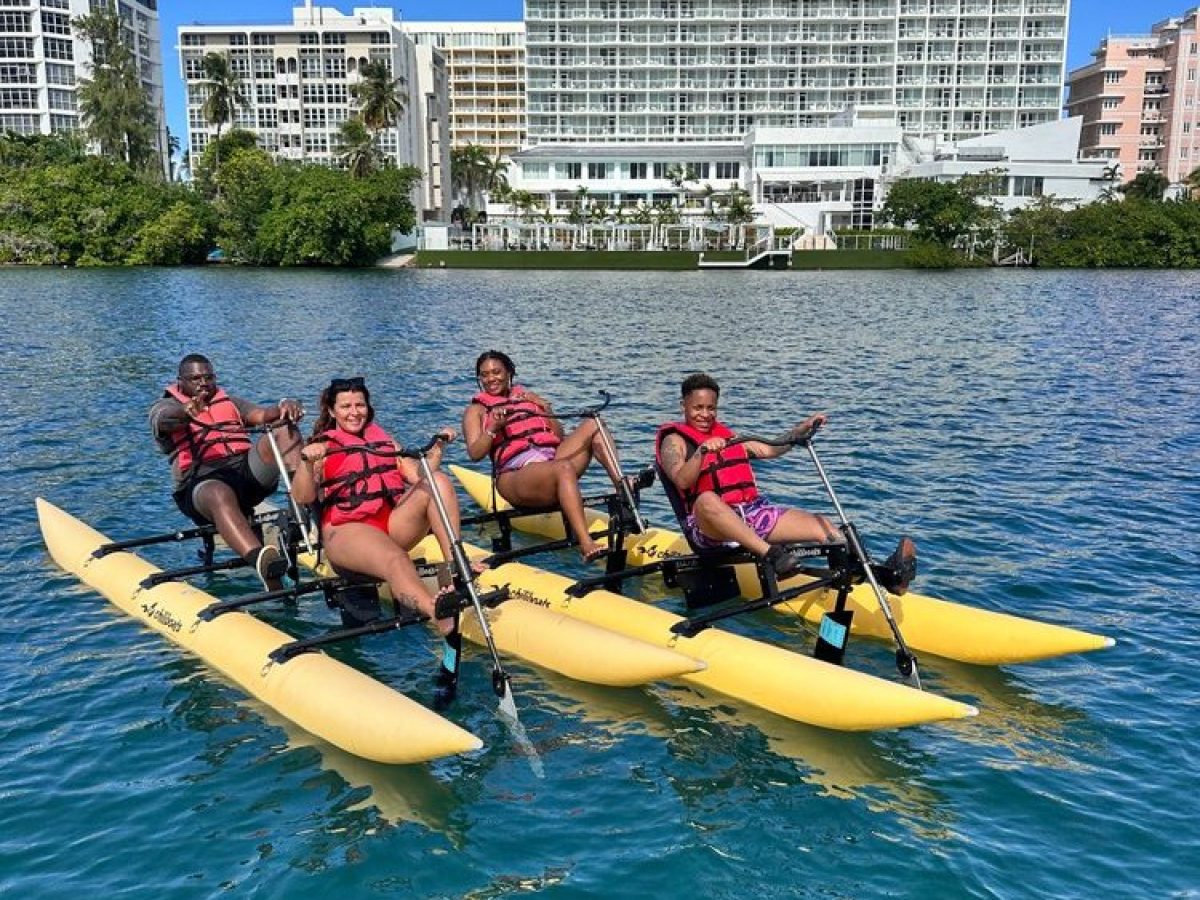 a group of people riding on the back of a boat in the water