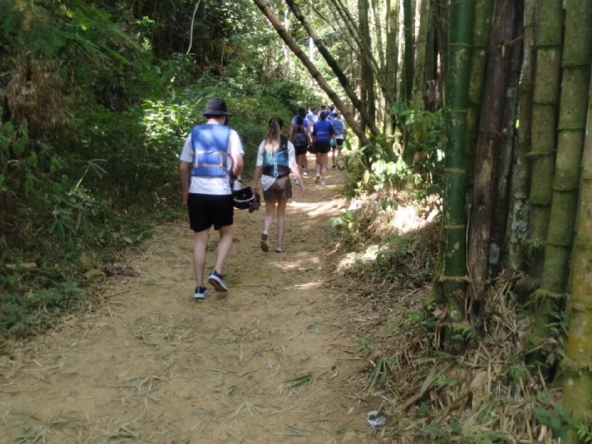a man riding a bike down a dirt path in a forest
