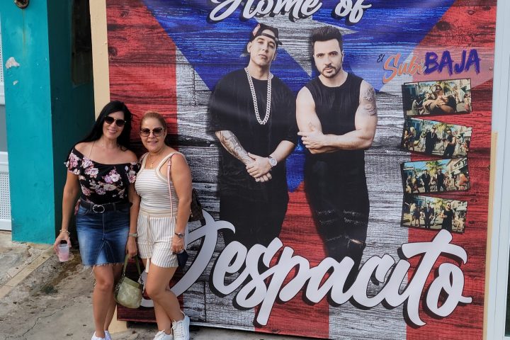 Luis Fonsi et al. standing in front of a graffiti covered wall