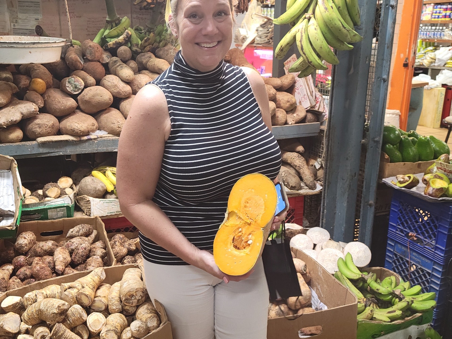 a woman standing in front of a produce stand