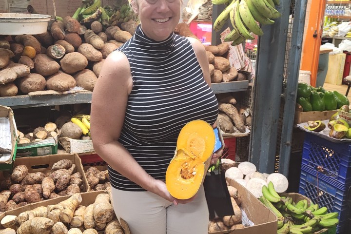 a woman standing in front of a produce stand