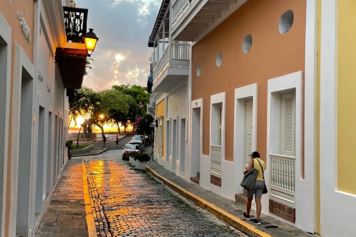 a person walking down a sidewalk next to a building