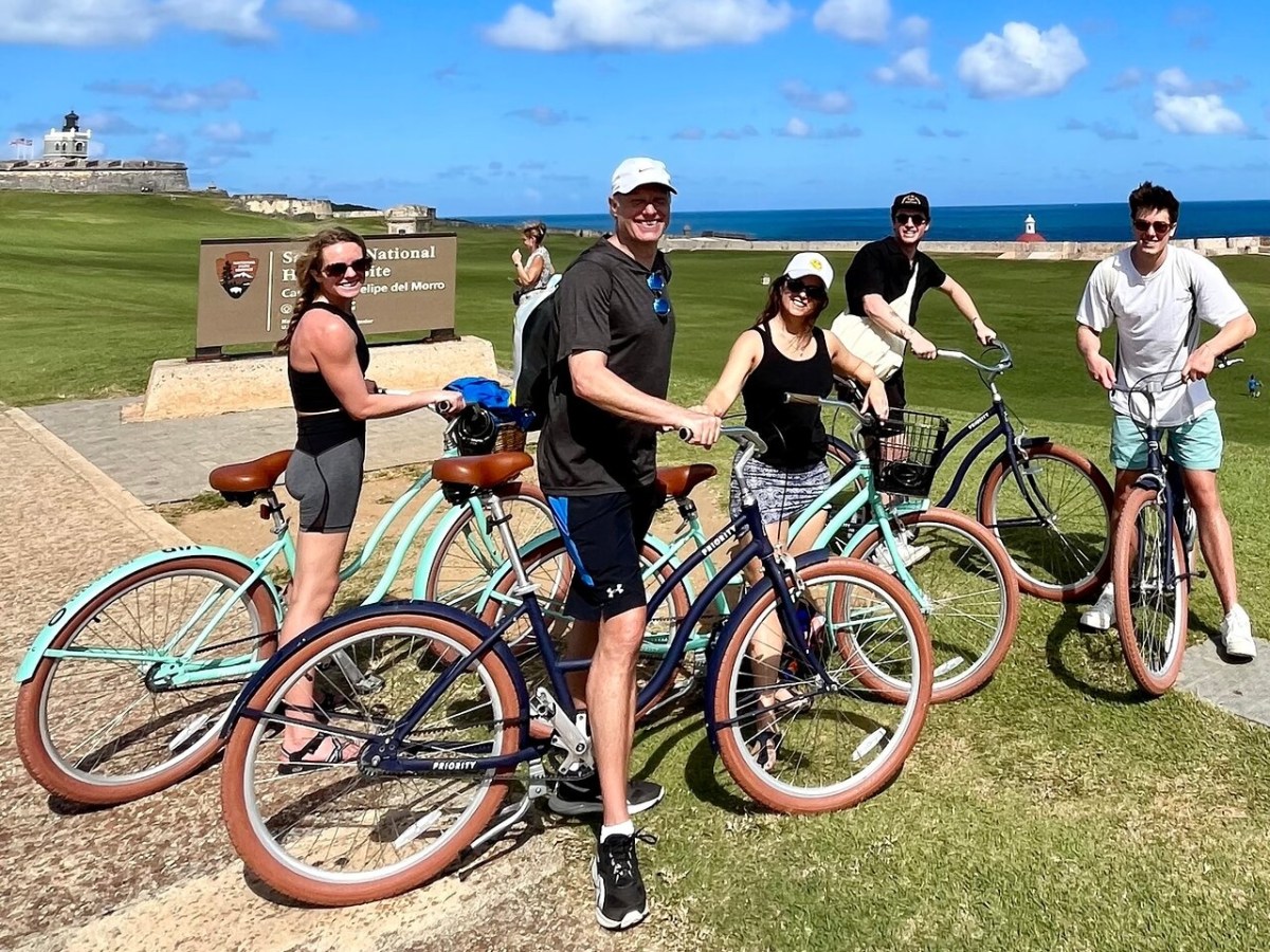 a group of people riding on the back of a bicycle