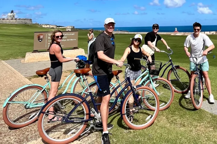 a group of people riding on the back of a bicycle