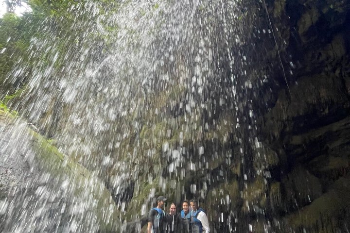 a group of people standing next to a waterfall
