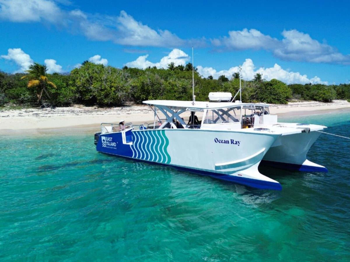 a blue and white boat sitting next to a body of water