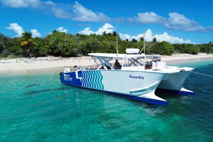 a blue and white boat sitting next to a body of water