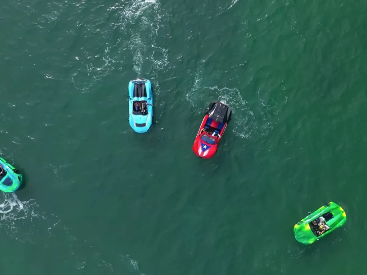 Four colorful jet skis on green water, viewed from above.