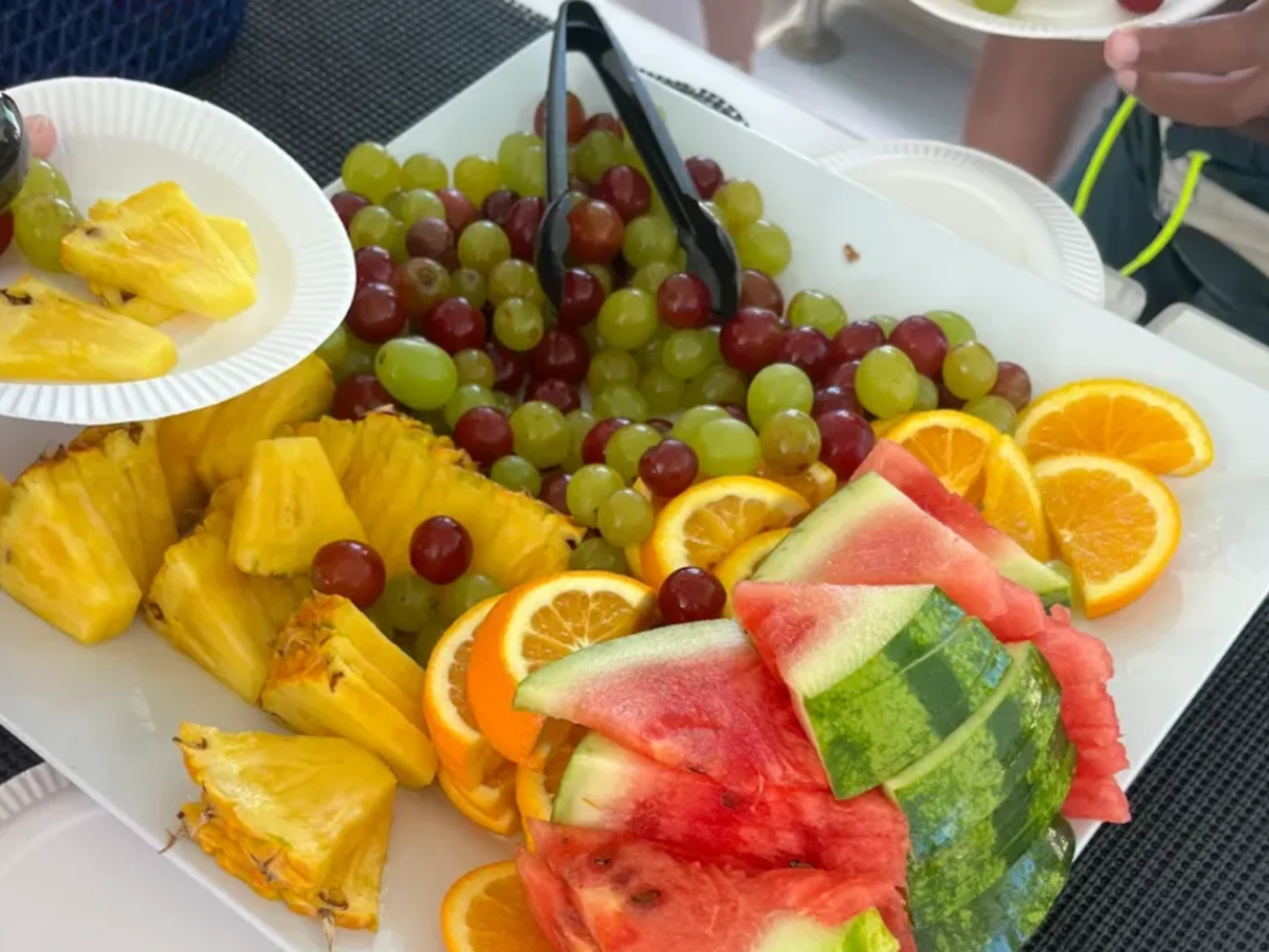 A platter with watermelon, pineapple, grapes, and orange slices.